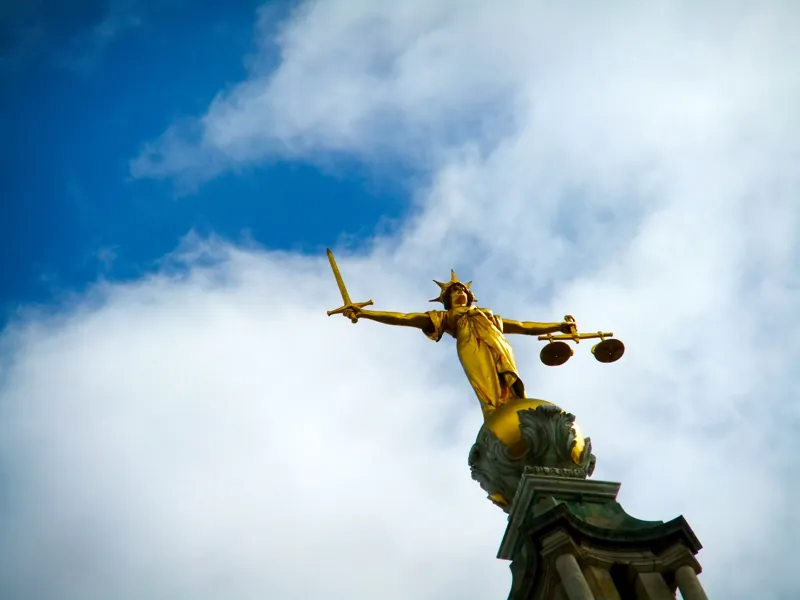 Estátua da Justiça com a balança contra o céu